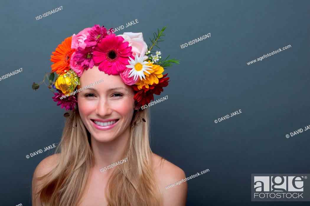 Stock Photo: Young woman wearing garland of flowers on head.