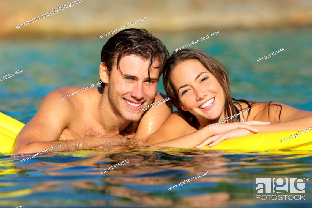 Stock Photo: Happy couple bathing on the beach in summer vacation with a perfect white smile and looking at camera.
