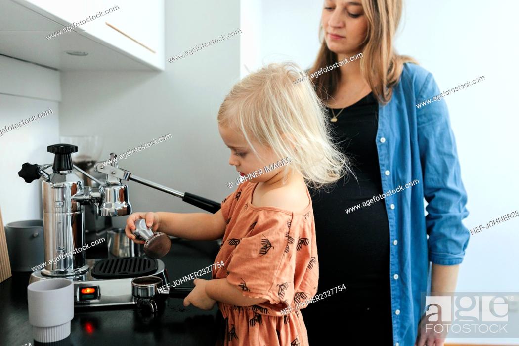 Stock Photo: Mother with daughter making coffee.