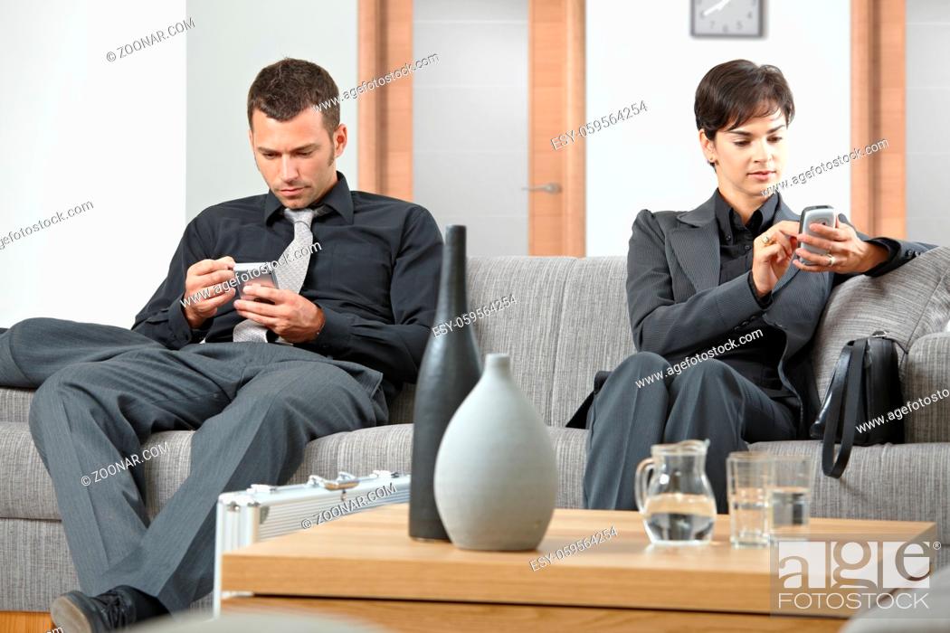Stock Photo: Business people sitting on sofa at office anteroom waiting.