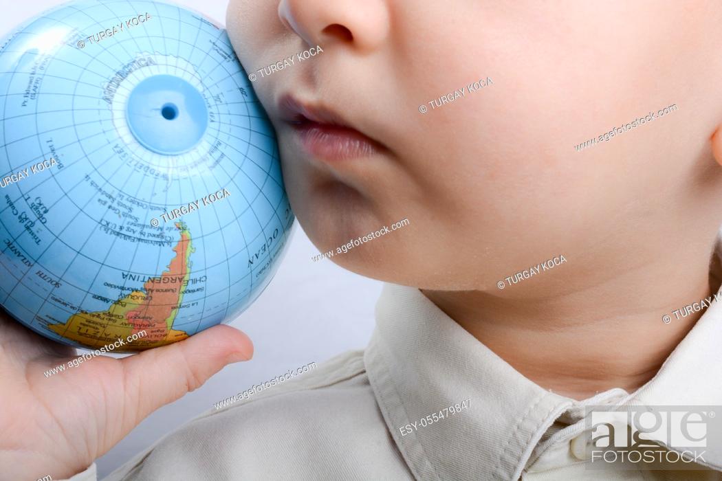 Stock Photo: Baby holding a small globe in hand on white background.