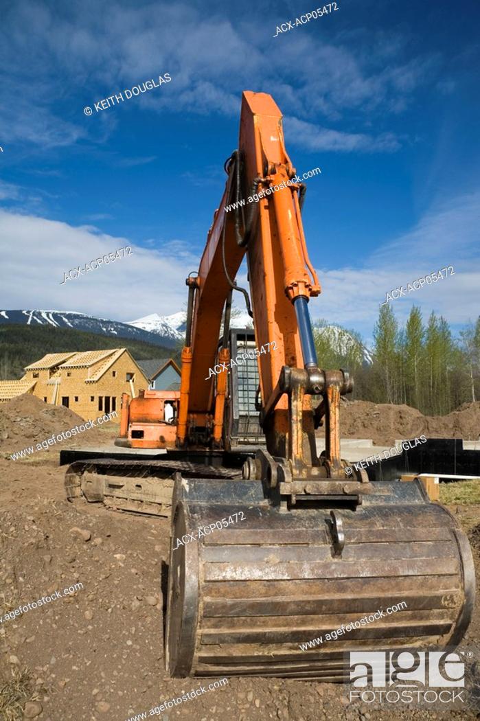 Stock Photo: Excavator at new home subdivision, Smithers, British Columbia, Canada.