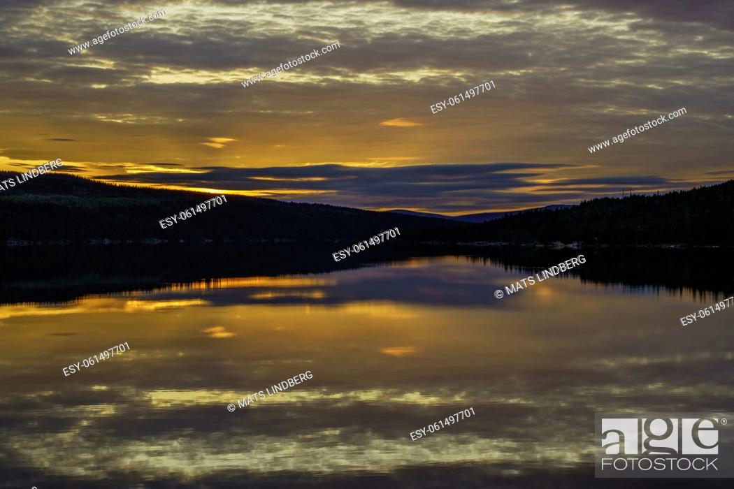 Stock Photo: Sunset at Stora luleälven with nice color in the sky and reflection in the water, some rocks in the water, Jokkmokk, Stora luleälven, Swedish Lapland, Sweden.