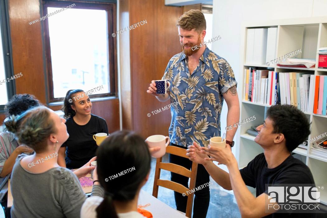 Stock Photo: Creative business people enjoying coffee and tea in office.