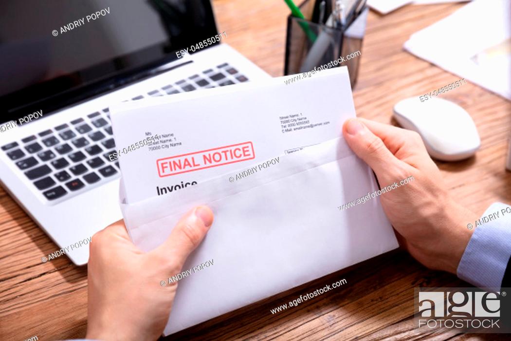 Stock Photo: Close-up Of A Person's Hand Opening The Envelope With Final Notice Invoice In It.