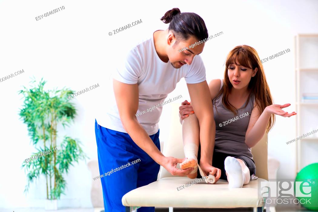 Stock Photo: The leg injured woman visiting young doctor traumatologist.