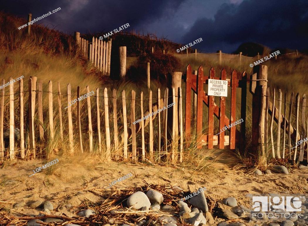 Stock Photo: Wales, Gwynedd, Harlech, Beach scene with fence and gate in sand dunes.