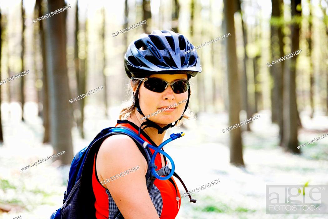 Stock Photo: Mountain biker standing in forest.