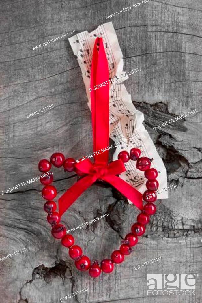 Stock Photo: Top view of music sheet and rosehip heart for christmas decoration natural.