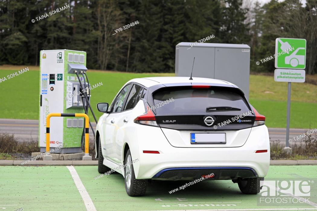Stock Photo: Salo, Finland - November 23, 2018: Nissan Leaf electric car charging battery at Fortum Charge & Drive Fast Charger in South of Finland, rear view.