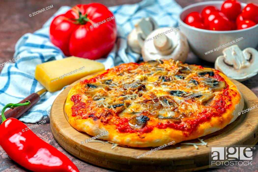 Photo de stock: Pizza with vegetables, mushrooms and two types of cheese is served on a wooden serving board, selective focus.