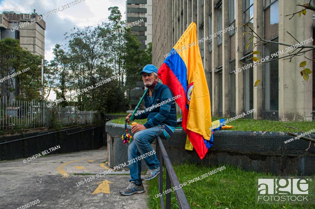 Stock Photo: An elderly men participates in demostrations with a Colombian flag in Bogota, Colombia on May 7 2021 after peaceful demonstrators against the tax and health.