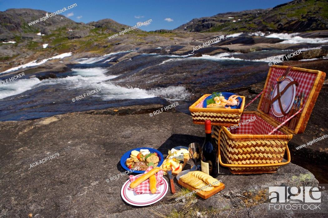 Stock Photo: Picnic hamper beside a waterfall with a Helicopter in the background in the Mealy Mountains, Southern Labrador, Newfoundland & Labrador, Canada.