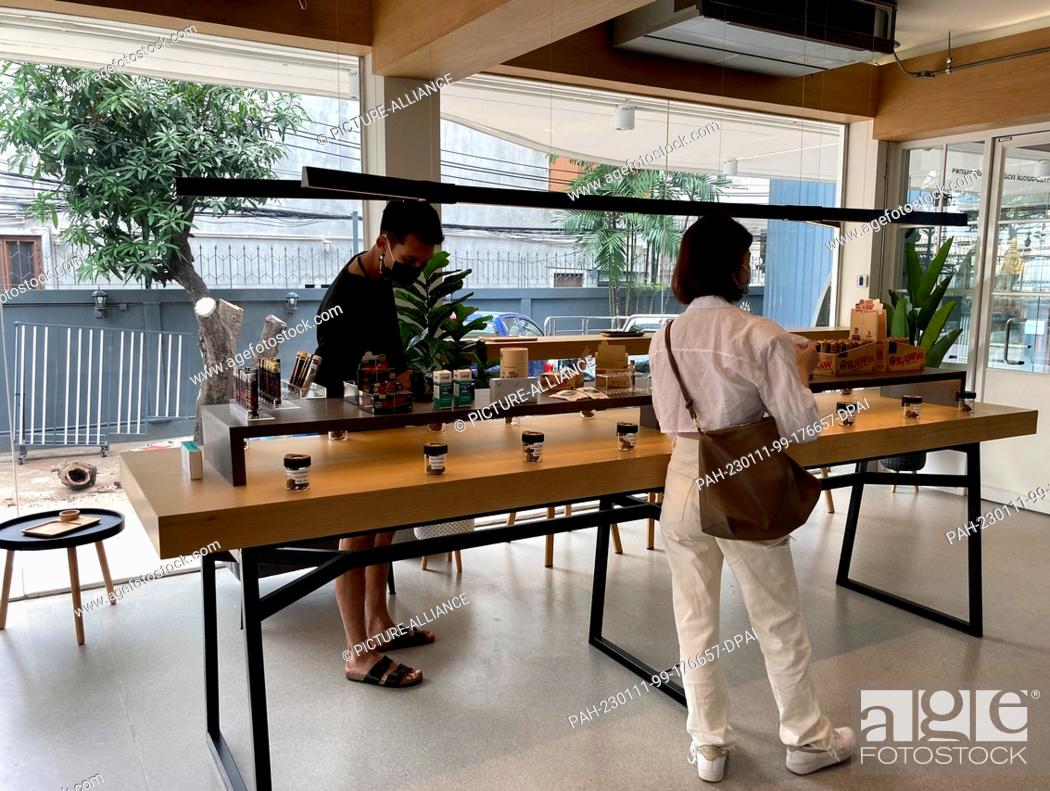 Stock Photo: PRODUCTION - 08 January 2023, Thailand, Bangkok: Customers look at what's on offer at the ""Cannabis Kingdom"" store in the Silom district.