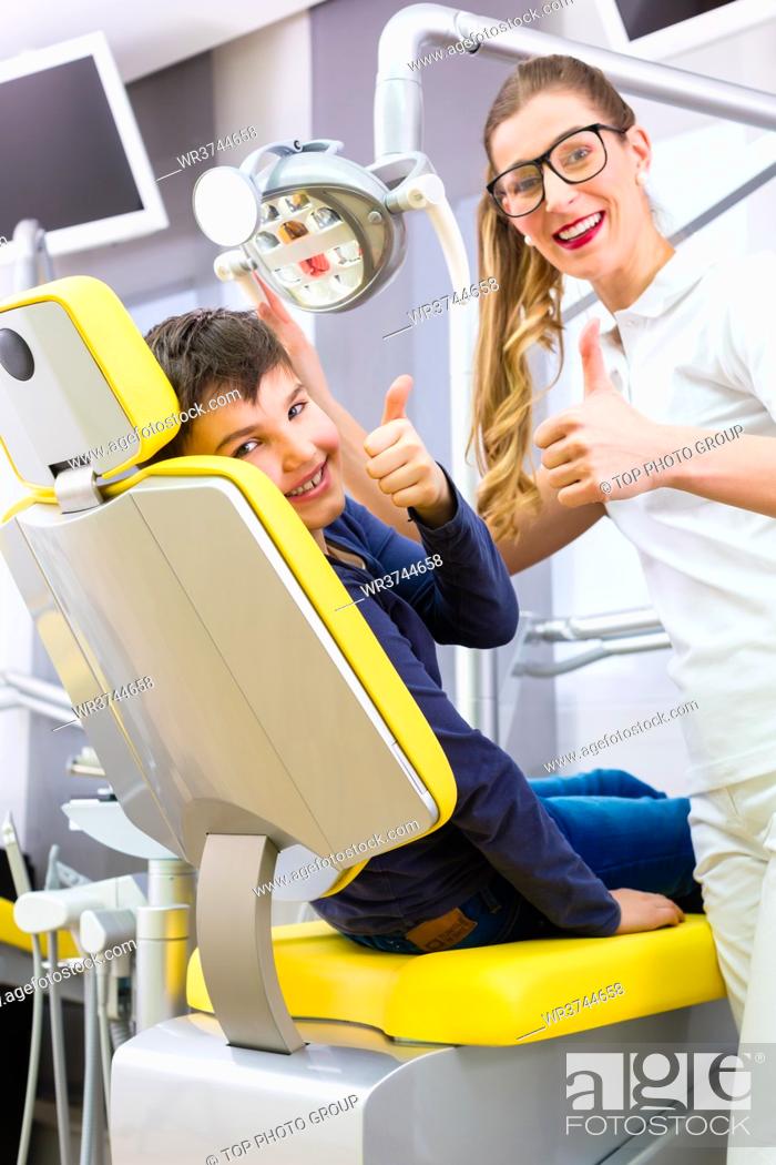 Stock Photo: Dentist giving boy advice in dental surgery.