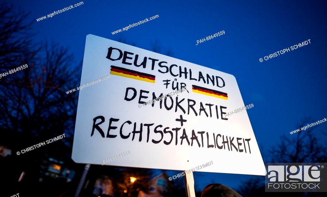 Stock Photo: A sign reading 'Deutschland für Demokratie + Rechtsstaatlichkeit' (lit. 'Germany for democracy and constitutional legality') is held up during a demonstration.
