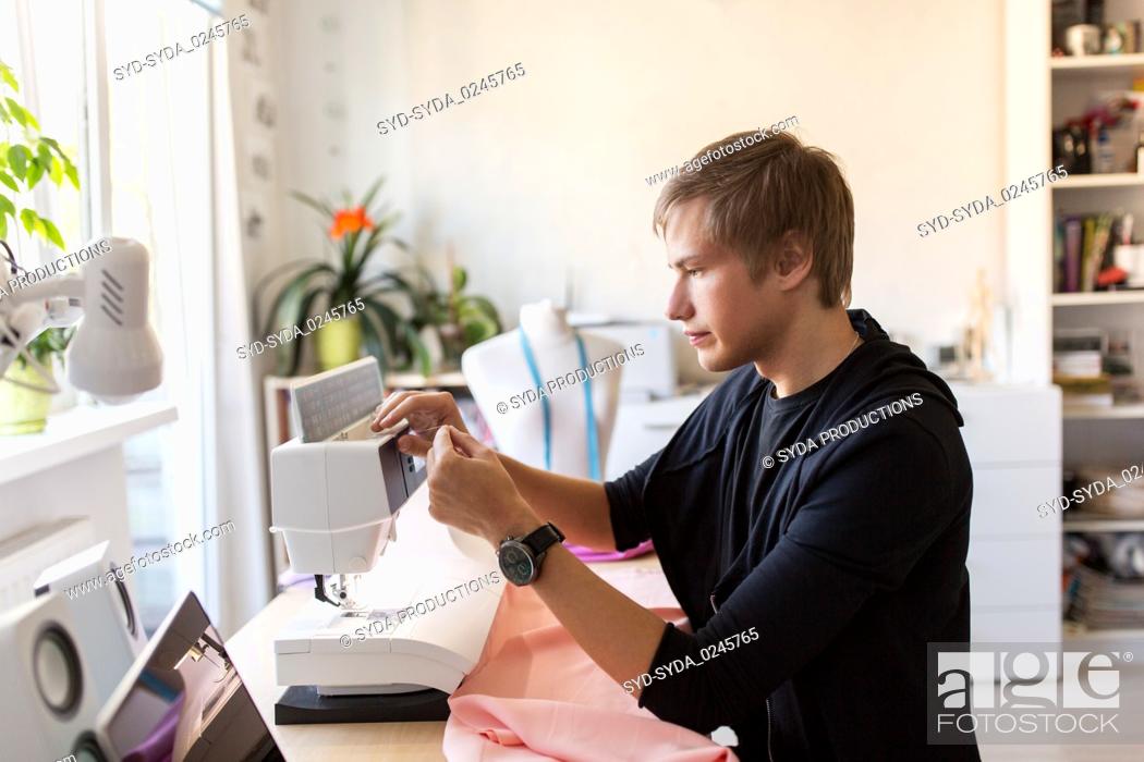 Stock Photo: fashion designer with sewing machine at studio.