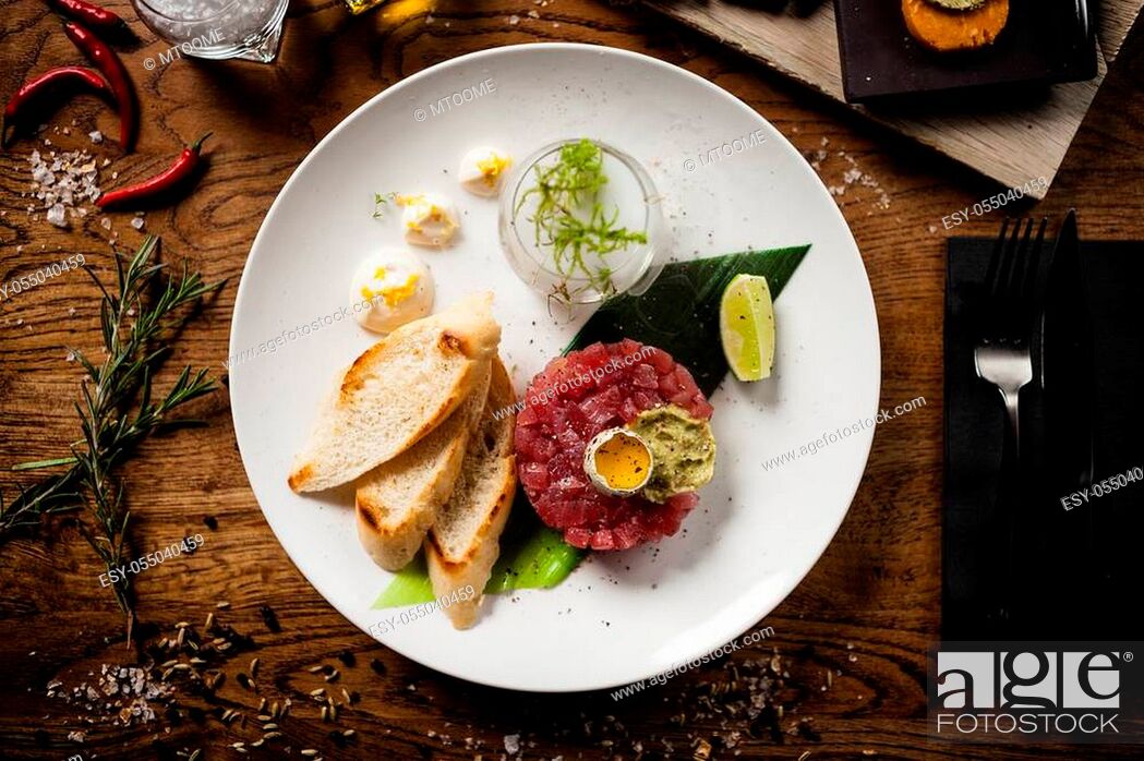 Stock Photo: Tuna tartare: Guacamole quail egg baguette on a plate. Delicious healthy raw food closeup served for lunch on a table in modern gourmet cuisine restaurant.