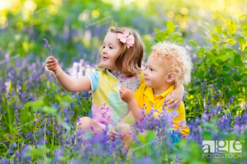 Stock Photo: Kids gardening. Children play outdoors in bluebells meadow. Little girl and boy, brother and sister, work in the garden, planting bluebell flowers.