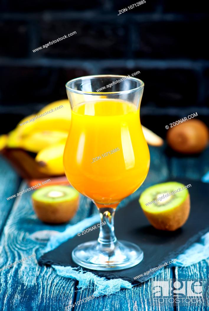 Stock Photo: juice from kiwi and banana in the glass and on a table.