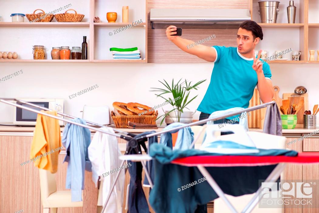 Stock Photo: Young man husband doing clothing ironing at home.