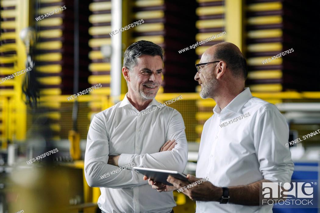 Stock Photo: Two businessmen using tablet in a factory.