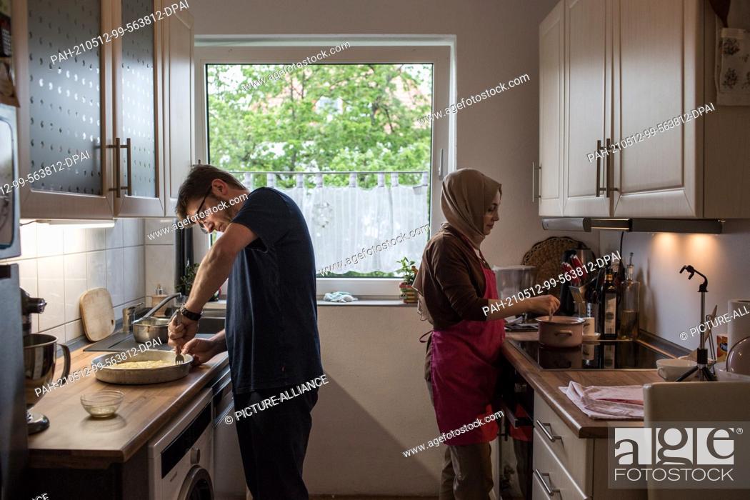 Stock Photo: PRODUCTION - 10 May 2021, North Rhine-Westphalia, Minden: Hatice Bahadir (r) and Abdurrahman Bahadir prepare the iftar together in their kitchen.