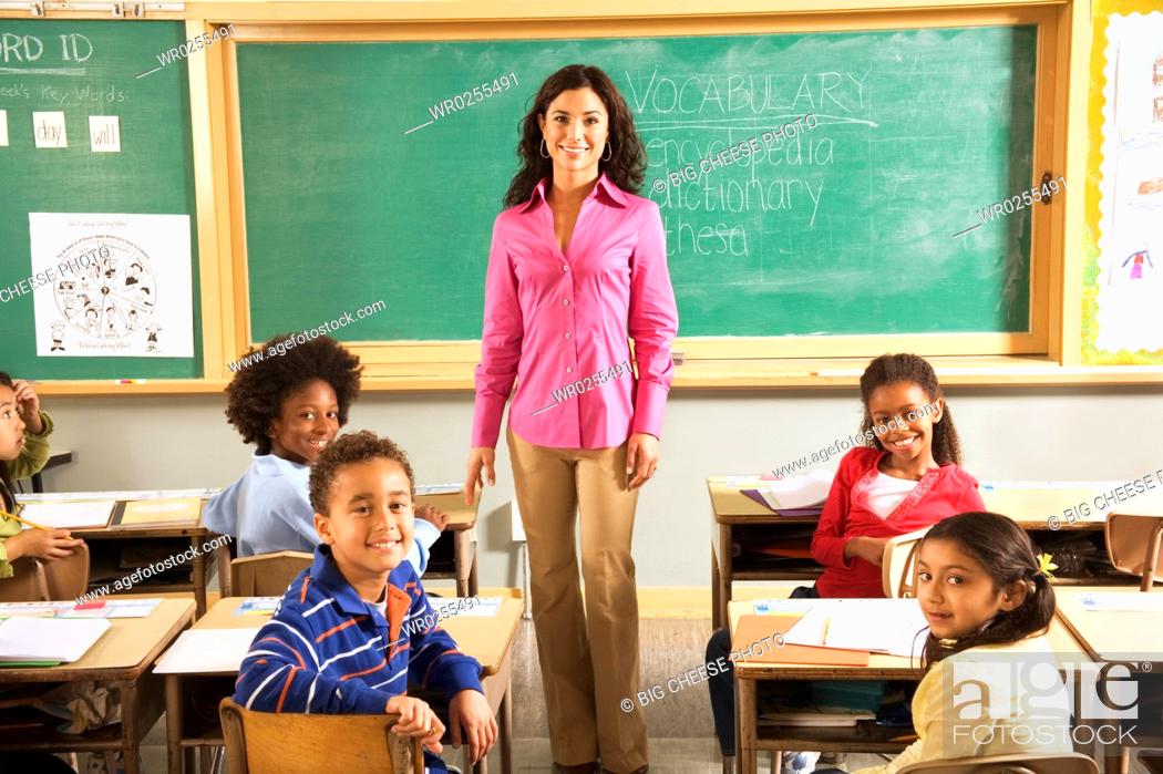Stock Photo: Portrait of female teacher and students in classroom.
