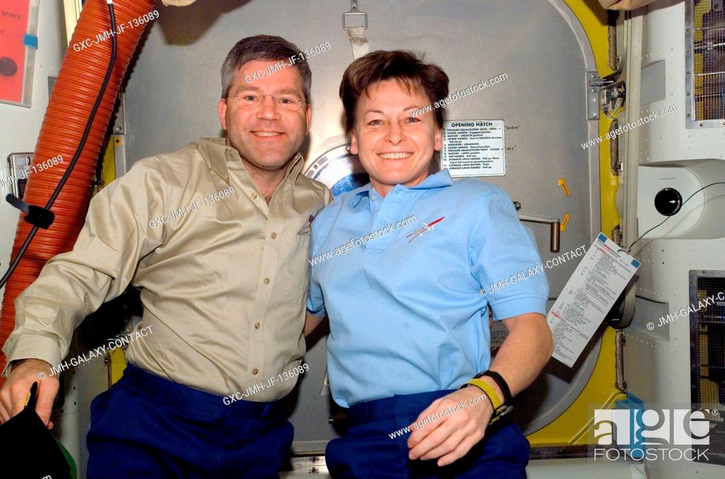 Stock Photo: Astronauts Steve Frick, STS-122 commander, and Peggy Whitson, Expedition 16 commander, take a moment for a photo in the Quest Airlock of the International Space.
