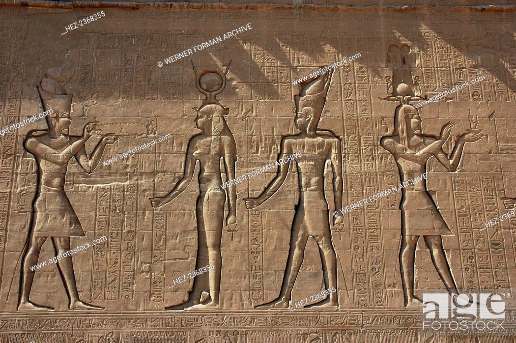 Stock Photo: Reliefs on the outer back wall of the temple complex, Edfu, Egypt. Reliefs depicting a pharaoh burning incense for the goddess Isis.
