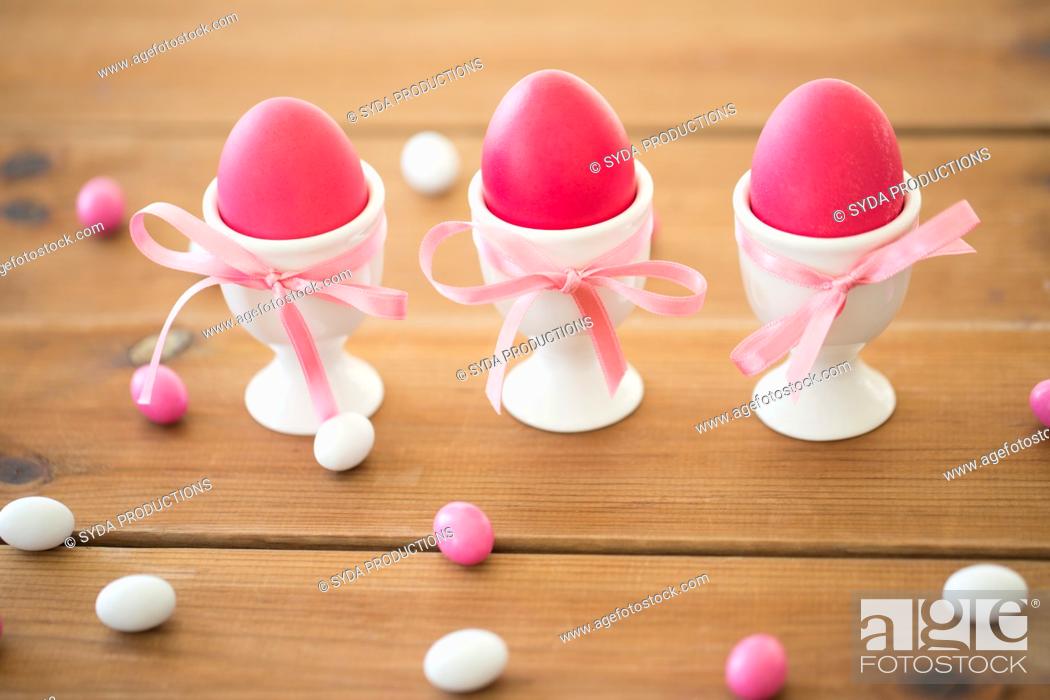 Stock Photo: easter eggs in holders and candy drops on table.
