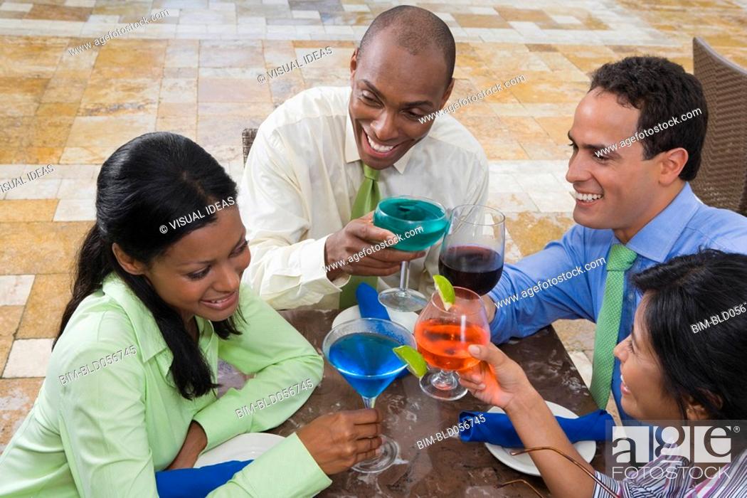 Stock Photo: Hispanic couples toasting with cocktails.