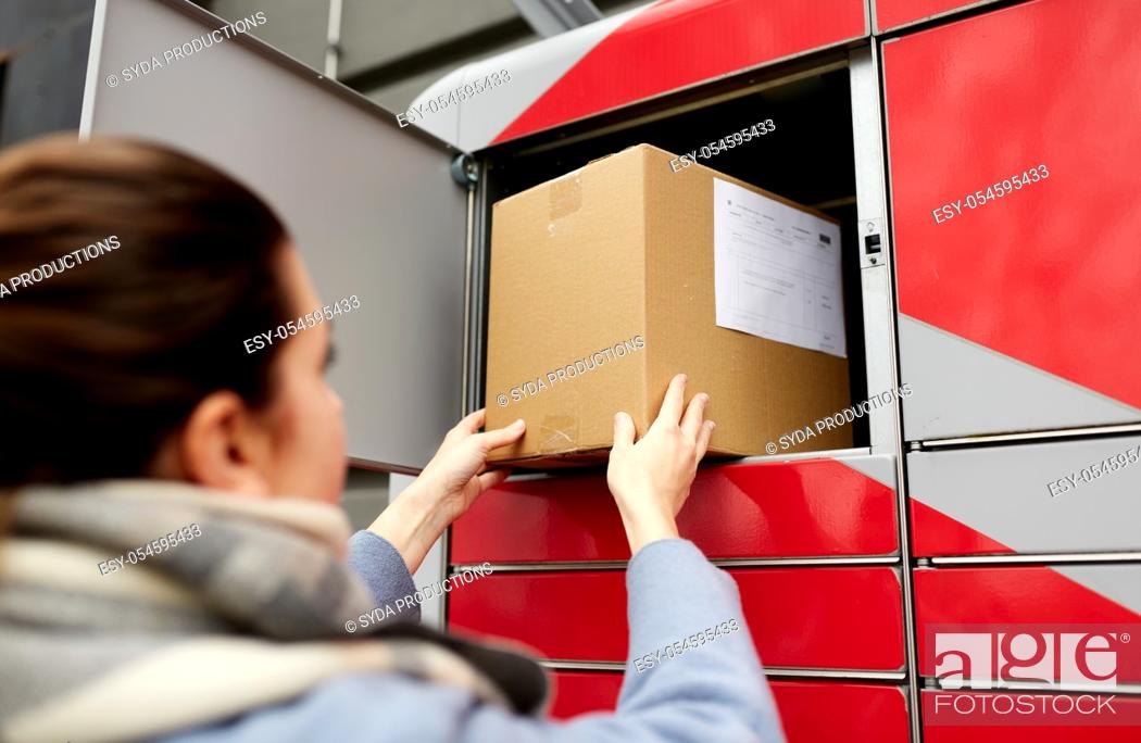 Stock Photo: woman putting box to automated parcel machine.