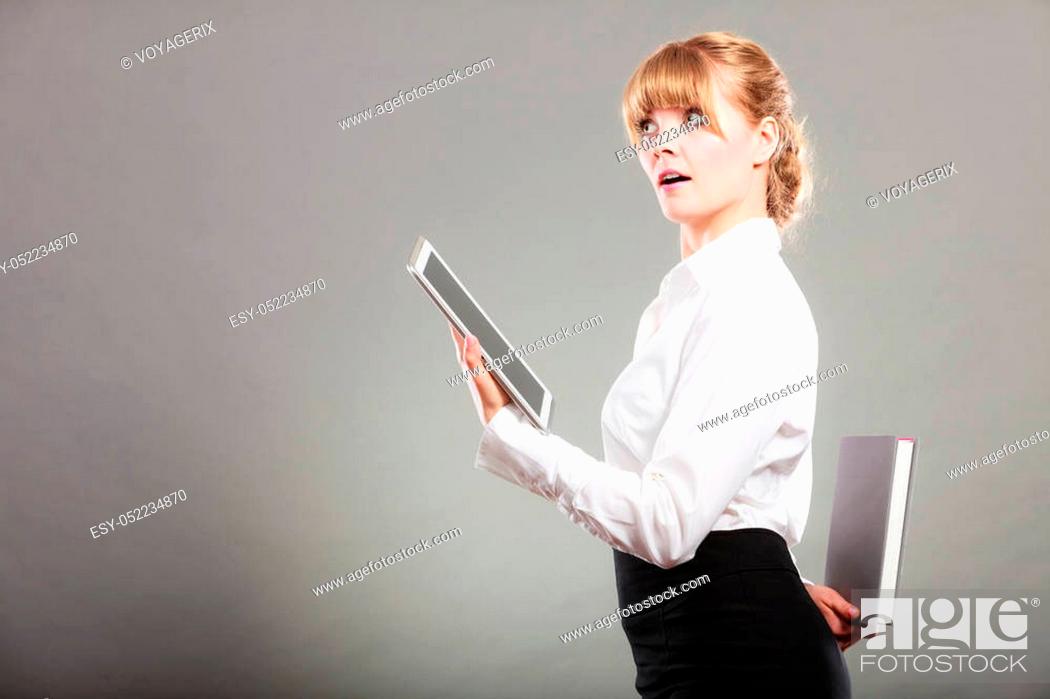 Stock Photo: Woman learning with ebook reader holding book behind back. Choice between modern educational technology and traditional way method.