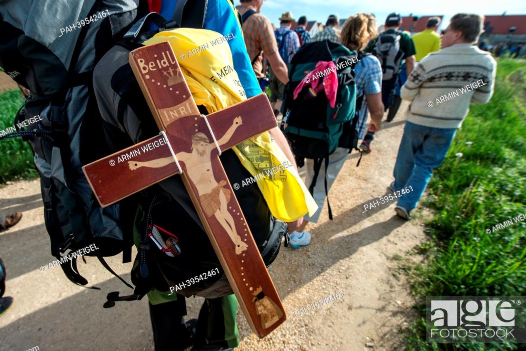 Stock Photo: A pilgrim carries a wooden cross a he takes part in Germany's largest pilgrimage on foot in Regensburg, Germany, 16 May 2013.