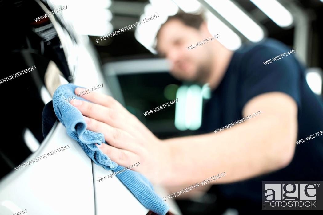 Stock Photo: Close-up of man working in modern car factory wiping finished car.