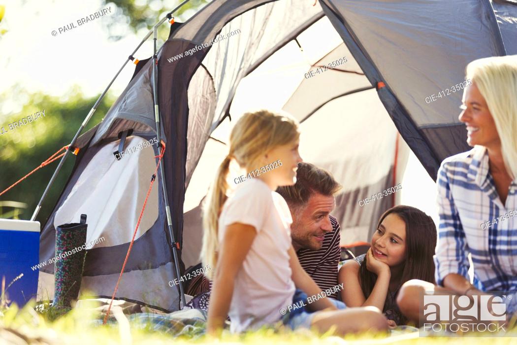 Stock Photo: Smiling family talking and relaxing outside sunny tent.