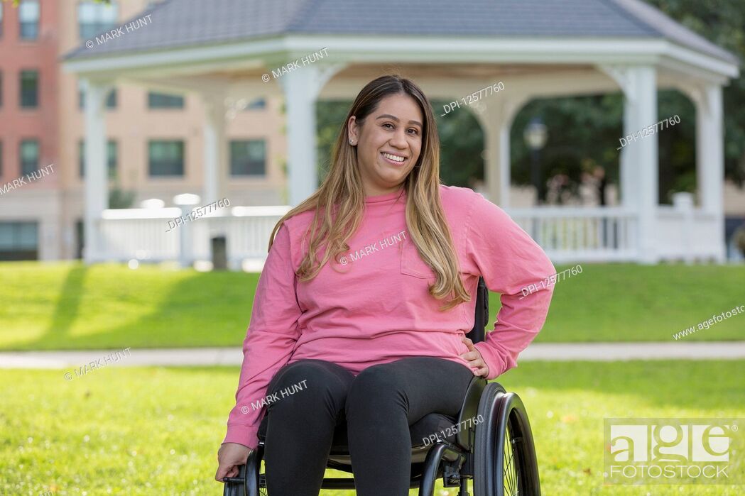 Stock Photo: Woman with Spinal Cord Injury sitting in wheelchair in a park.