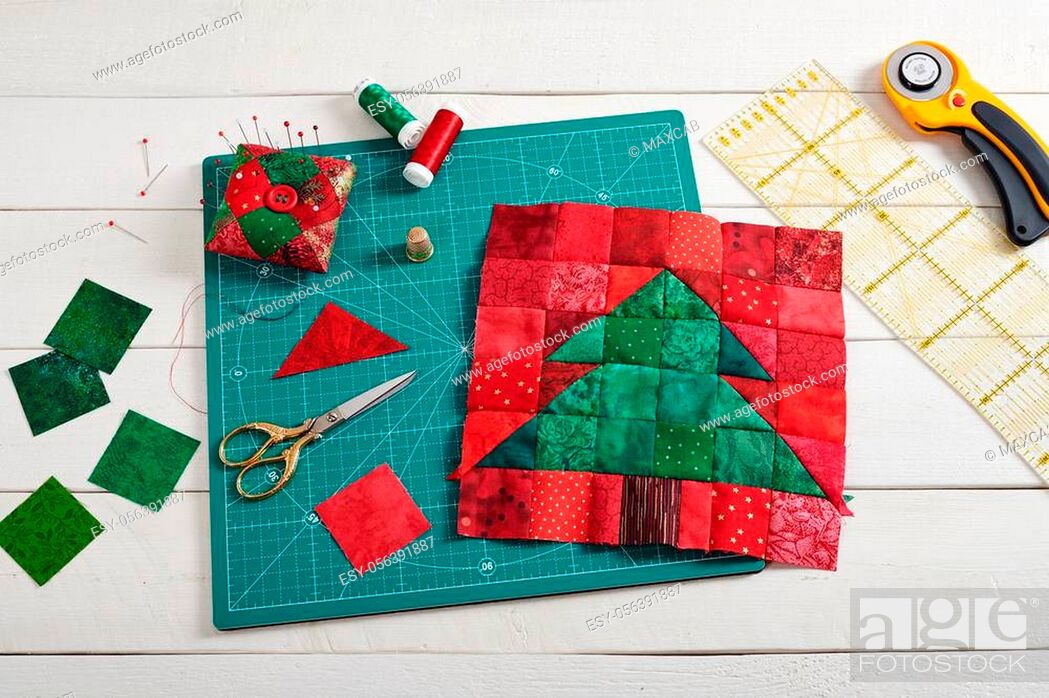 Stock Photo: Christmas tree patchwork block, pieces of fabric, quilting and sewing accessories on white wooden background.