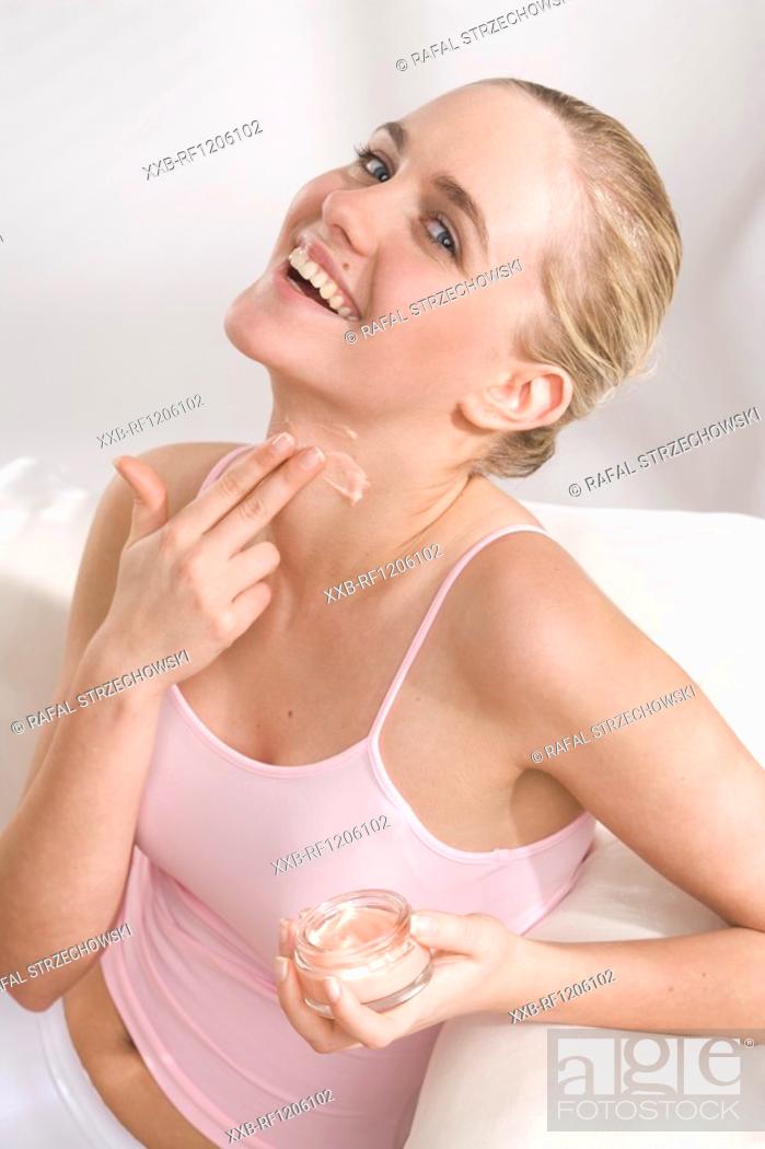Stock Photo: woman applying cream on neck.