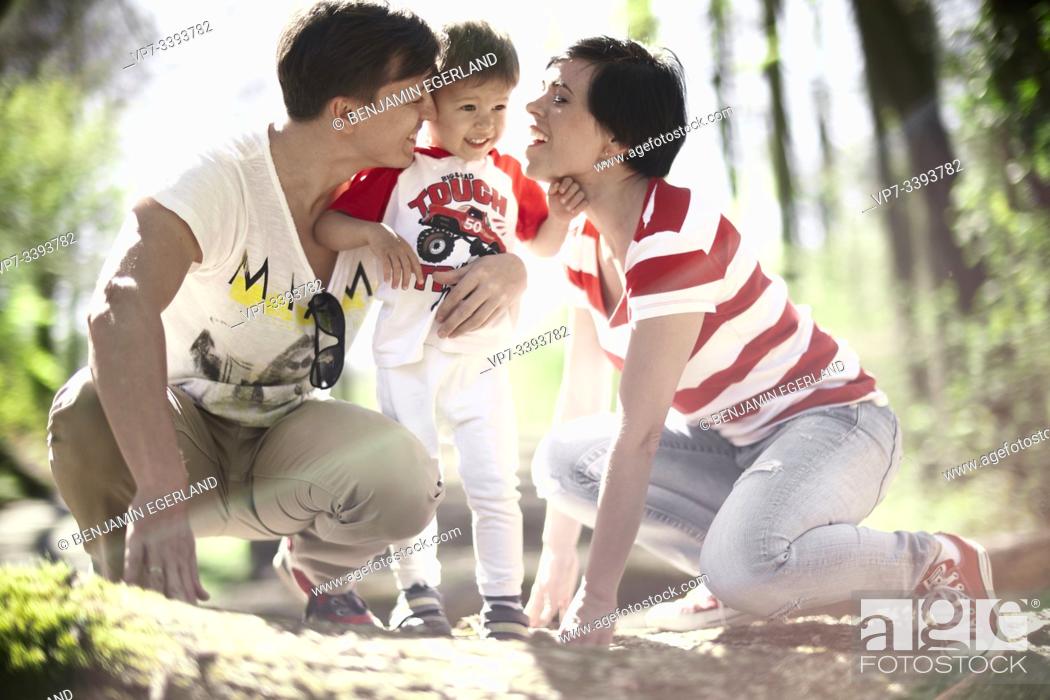 Stock Photo: parents looking at toddler child in forest, at Herrenchiemsee, Chiemsee, Bavaria, Germany.