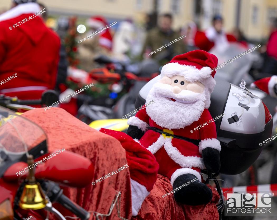 Stock Photo: 10 December 2022, Berlin: A plush Santa Claus sits on a Christmas-decorated motorcycle during the ""Santa Claus on Road"" campaign.
