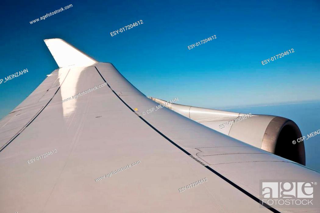 Stock Photo: wings of an aircraft in the blue clear sky.