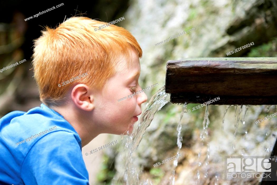 Stock Photo: Boy drinking water from a runlet.