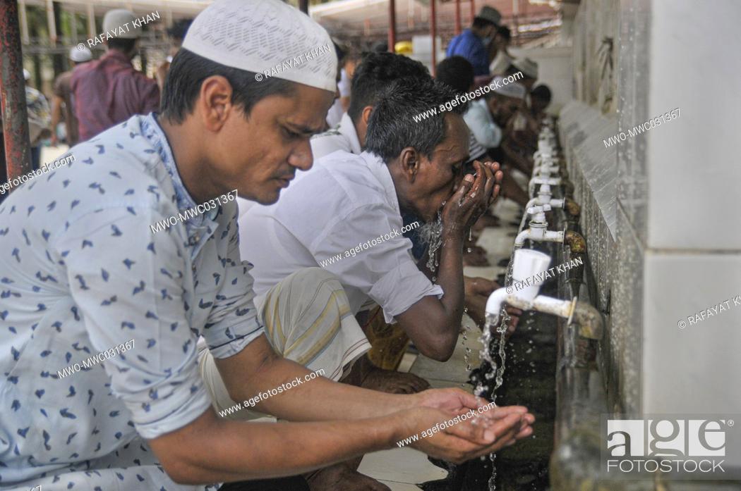 Stock Photo: Muslims perform ablution to attend Friday prayers during the coronavirus pandemic at Hazrat Shahjalal Dorgarh Mosque, while maintaining social distancing and.