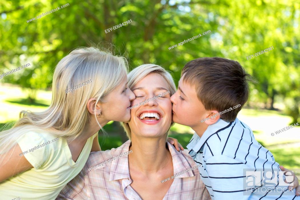 Stock Photo: Sister and brother kissing their mother.