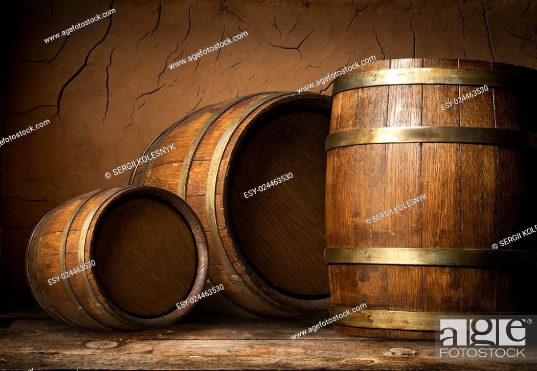 Stock Photo: Three wooden barrels near clay wall in cellar.