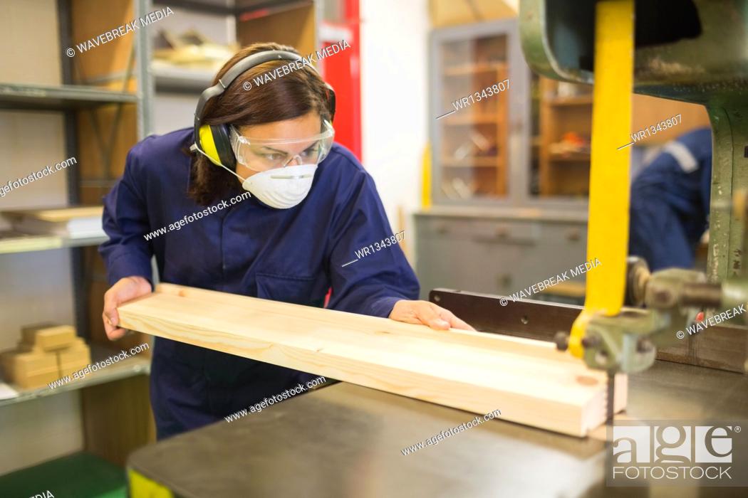 Stock Photo: Trainee wearing safety protection using saw.