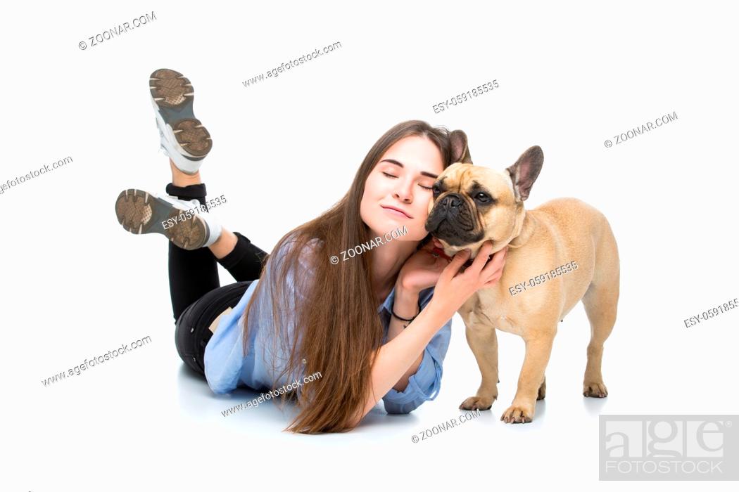 Stock Photo: Beautiful young woman with long hair in jeans shirt lying with adult french bulldog girl. Studio shot isolated on white. Copy space.