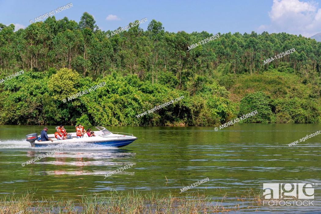 Stock Photo: Motorboat drives over lake, jungle,.